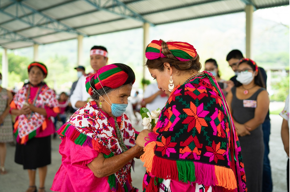 two women holding hands in colourful clothing
